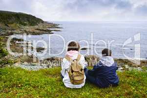 Children sitting at Atlantic coast in Newfoundland