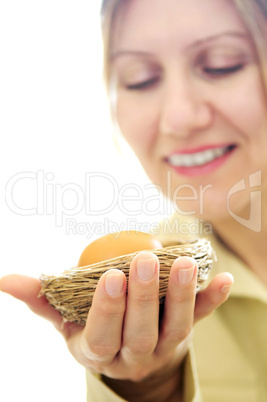 Mature woman holding a nest with an egg