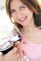 Mature woman toasting with red wine