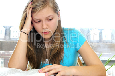 Teenage girl studying with textbooks