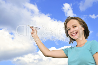 Young girl holding paper airplane