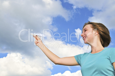 Young girl holding paper airplane