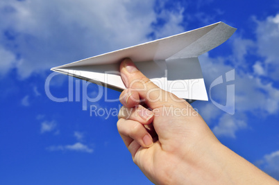 Hand holding paper airplane