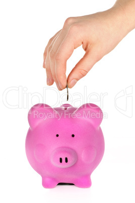 Hand putting coin in piggy bank
