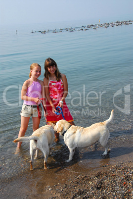 Two girls playing with dogs