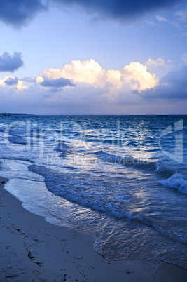 Ocean waves on beach at dusk