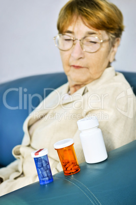 Elderly woman looking at pill bottles