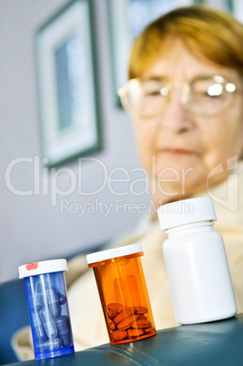 Elderly woman looking at pill bottles