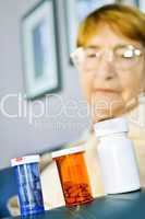 Elderly woman looking at pill bottles