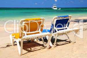 Chairs on sandy tropical beach