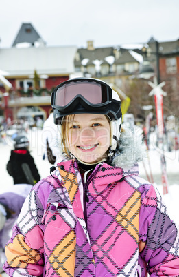 Happy girl in ski helmet at winter resort