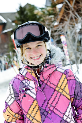 Happy girl in ski helmet at winter resort