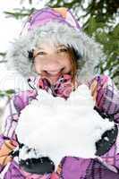 Happy winter girl holding snow