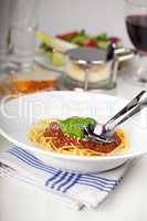 Teller mit Spaghetti Bolognese und Basilikumblatt