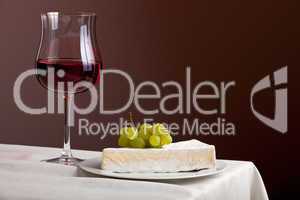 Glas Rotwein und Camembert mit Trauben