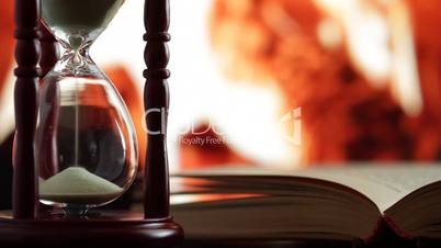 hourglass and an open book.