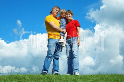 happy family stand on green grass under sky