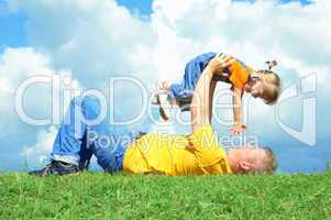 father with daughter on green grass