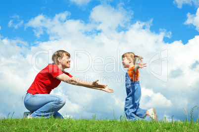 little girl run to mother embrace on green grass