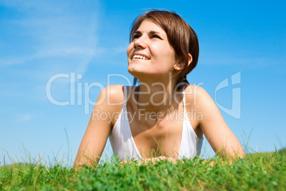 Young woman lying on the green grass