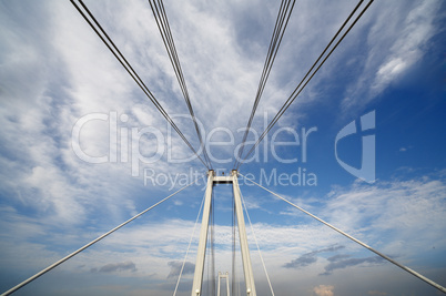 cable of bridge over blue sky