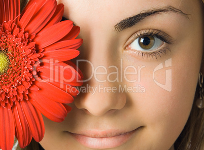 close-up woman eyes and  gerbera flower in front of her head