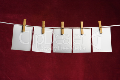 five white slip of paper attach to rope clothes peg