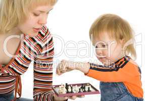 pretty baby and mother play chess