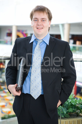 Happy young businessman with laptop