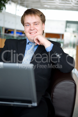 Happy young businessman with laptop