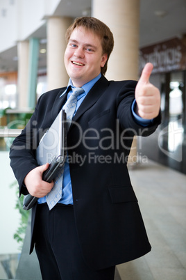 Happy young businessman with laptop