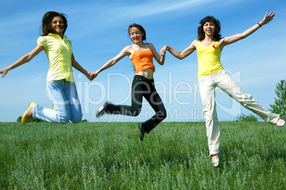 three girlfriend jump in green field