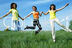 three girlfriend jump in green field