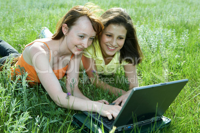 Two beautiful girls with laptop computer