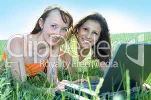 Two beautiful girls with laptop computer