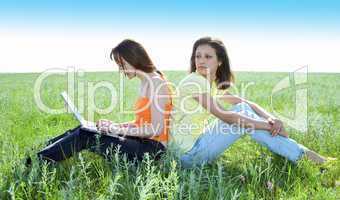 Two beautiful girls with laptop computer