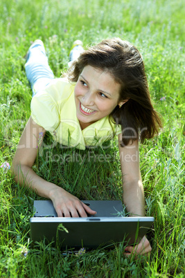 pretty woman with laptop on the green grass