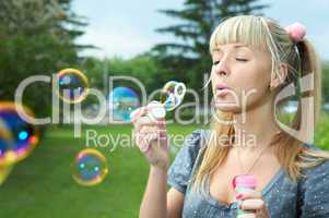 young girl makes soap bubble