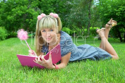 young blonde woman reading book in park