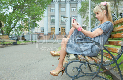 blonde girl sit on bench
