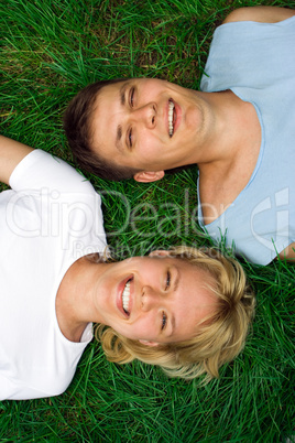 man and woman lie on grass