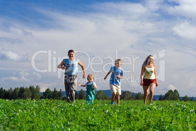 family mother father and two child run on field