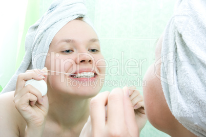 young beauty woman clean teeth thread