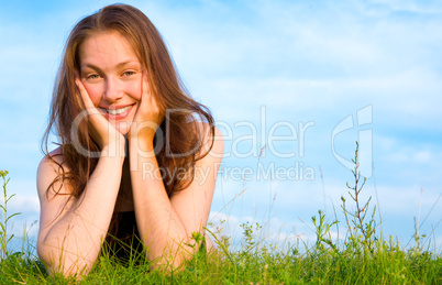 Young woman lying on the green grass