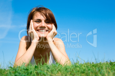 Young woman lying on the green grass