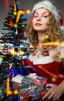 Beautiful young woman in Santa hat with christmas tree