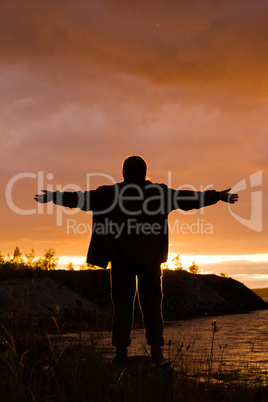 man looks at sunset