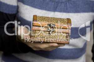 Hands holding a decorative wooden box