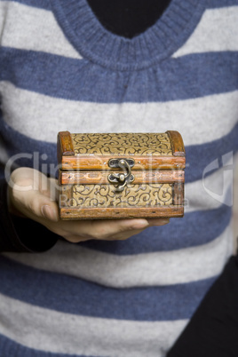 Hands holding a decorative wooden box