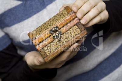 Hands holding a decorative wooden box